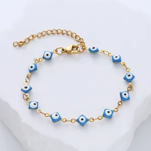 Close-up of golden evil eye bracelet with blue square enamel charms and lobster clasp
