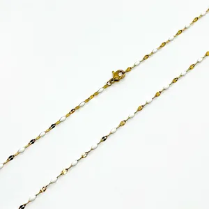 Detail von goldenem Karabinerverschluss und weißer Emaille-Kette für Damen