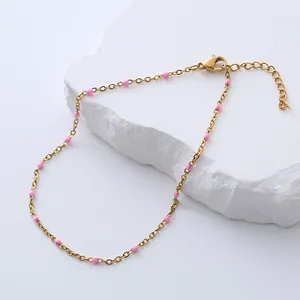Detail of gold stainless steel anklet with pink enamel beads and adjustable lobster clasp