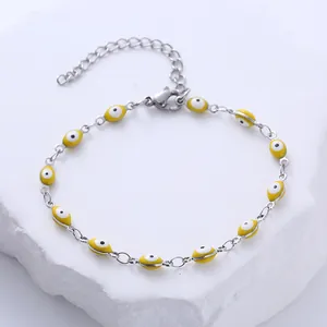 Détail du bracelet en acier inoxydable avec charmes œil grec jaunes et fermoir mousqueton