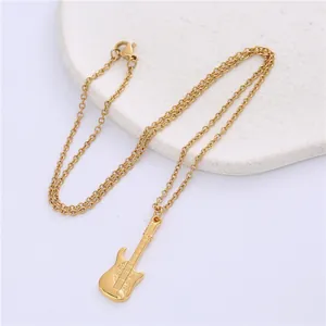 Macro shot of a gold stainless steel electric guitar pendant with detailed engravings