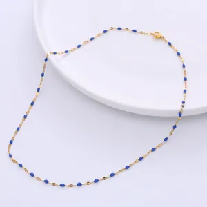 Detail der goldfarbenen Kette mit blauen Emaille-Perlen und Karabinerverschluss