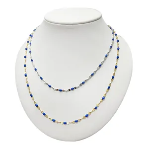 Minimalistische silberne und goldene Halsketten mit blauen Perlen auf einer weißen Büste