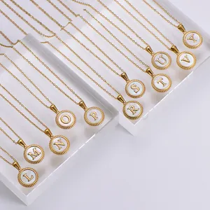 Detail of 18k gold plated stainless steel necklaces with white shell alphabet pendants