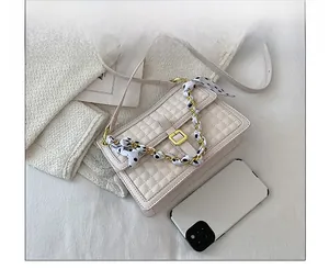 Sac bandoulière matelassé avec anse chaîne et foulard comparé à un smartphone
