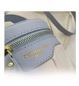 Close-up of golden zipper and quilted bicolor texture on a light blue bucket bag