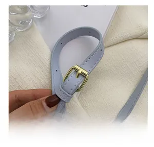 Detail of adjustable golden metal buckle on a lavender leather shoulder strap