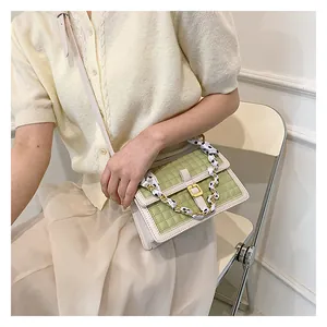 Détail du sac matelassé vert avec poignée en foulard de soie et fermoir doré élégant