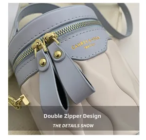 Detail of blue and beige bucket bag with wave quilting and golden double zippers