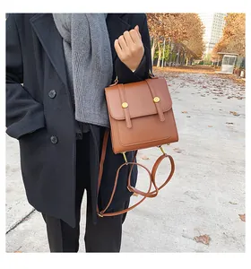 Detail van een vintage bruine PU-lederen rugzak met gouden gespen in herfstachtige sfeer