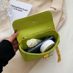 Vista dettagliata degli oggetti essenziali nella borsa baguette verde lime con catena