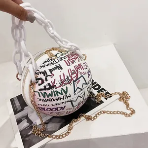 Macro shot of basketball-shaped bag with graffiti patterns and white resin chain