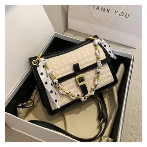 Détail du sac bandoulière matelassé avec bandoulière chaîne foulard et boucle dorée