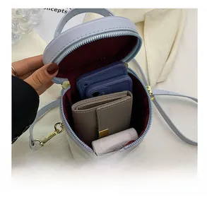 Internal view of light blue cylindrical bucket bag showing phone and wallet storage