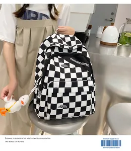 Dettaglio dello zaino a scacchi con scritte moda e tasca anteriore con zip in metallo