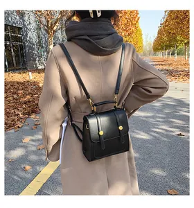Buitenopname van een vrouw met een zwarte vintage PU-lederen mini-rugzak in de herfst