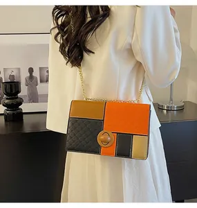 Dettaglio della borsa a tracolla color-block con pannelli arancioni testurizzati e catena oro
