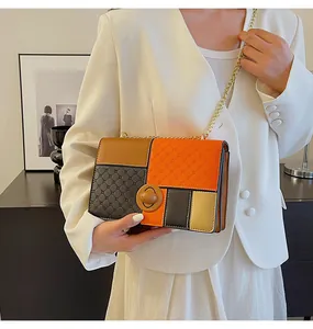 Dettaglio borsa a tracolla color-block con trapuntatura e catena in metallo dorato