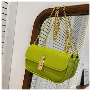 Dettaglio borsa baguette verde lime con catena dorata e fibbia metallica