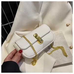 Dettaglio della borsa a patta bianco crema con chiusura in metallo dorato a onde