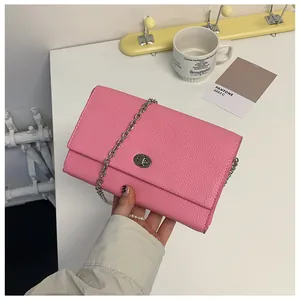 Dettaglio della pelle rosa martellata e della chiusura rotante argento della borsa