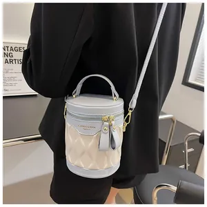 Detail of color-block barrel bucket bag featuring dual gold zippers and wave texture