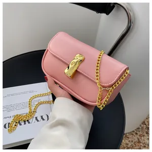 Dettaglio della borsa baguette in pelle rosa con fibbia dorata in stile lava metallica