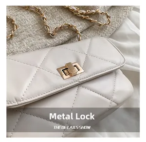 Detailed macro view of the gold hardware lock and cream quilted faux leather texture