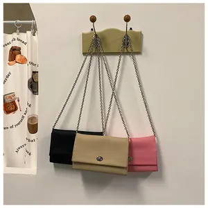 Tre borse a tracolla in ecopelle martellata nei colori nero, beige e rosa