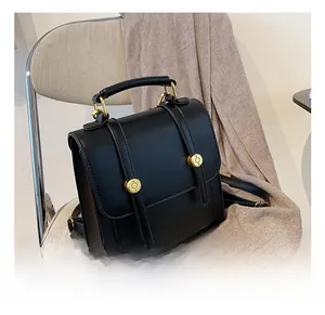 Detail showing the retro black PU leather texture with gold metal rings on a backpack