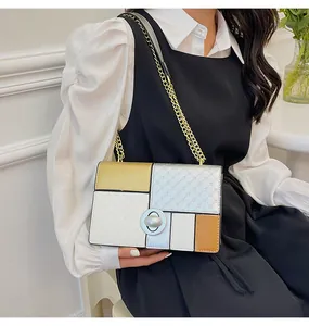 Dettaglio borsa a tracolla color block con catena dorata e chiusura a girello in metallo