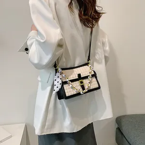 Sac bandoulière matelassé chic en beige et noir avec détail de foulard élégant