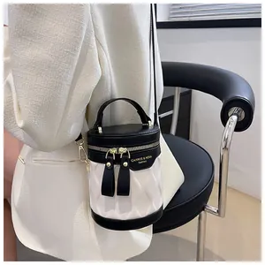 Close-up of stylish contrast color bucket bag with wave-embossed leather and gold accents