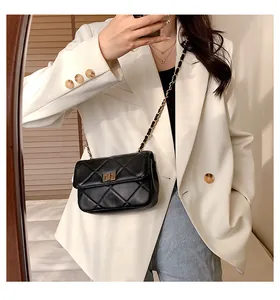 Mirror selfie showing a black quilted chain bag with gold hardware and a turn-lock clasp