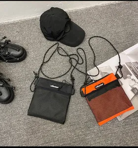 Close-up of nylon grid crossbody phone bags in black and orange for outdoor style
