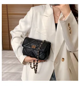 Detail of black quilted leather shoulder bag with gold metal twist lock and chain strap
