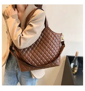 Close-up of brown quilted tote bag with golden hardware and detachable shoulder strap