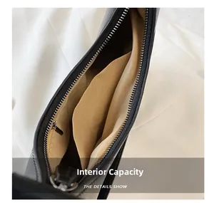 Detail view of the black leather bag's internal capacity with zipper pocket and lining