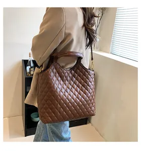 Brown quilted leather tote bag worn by model showing large capacity and shoulder strap