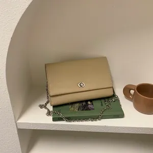 Borsa a tracolla chic in pelle beige a grana di litchi con catena e chiusura ad anello