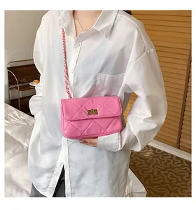 Pink quilted crossbody bag with gold twist lock and chain strap shown on a model