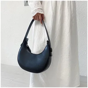 Detail of minimalist black crescent underarm bag with smooth matte leather texture