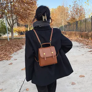 Retro bruine PU-lederen rugzak voor dames met gouden accenten in een herfstachtige setting