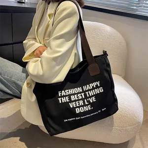 Minimalistische zwarte canvas shopper met letterprint en brede stoffen handvatten