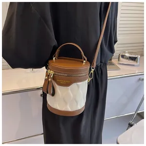 Brown and white bucket bag with ripple texture shown on model in a modern home setting