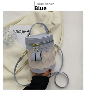 Close-up of blue and beige bucket bag with wave embossing and dual zipper closure