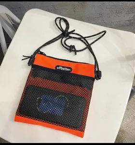 Detail of orange nylon shoulder bag featuring mesh pocket and offbetter label