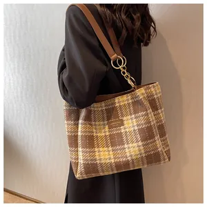 Dettaglio ravvicinato della borsa shopper scozzese vintage con tracolla in pelle marrone