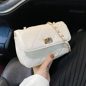 Quilted white crossbody chain bag with gold hardware and flap closure in car interior