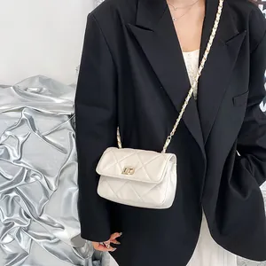 Chic white quilted crossbody bag with gold chain strap and metal turn-lock closure